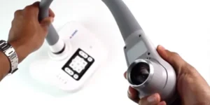 Hands adjusting a QOMO document camera with flexible arm and digital controls for classroom presentations, available from Encore Data Products