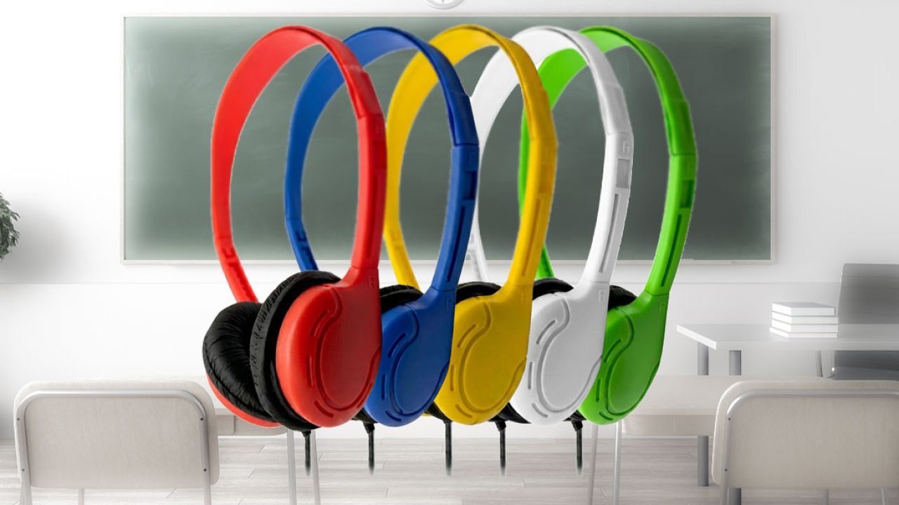 Colorful over-ear classroom headphones in red, blue, yellow, white, and green displayed in front of a classroom chalkboard, representing durable educational audio solutions from Encore Data Products